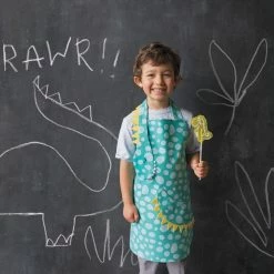 Now Designs Danica Jubilee Kid's Apron | Dino Daydream 9 Now Designs Danica Jubilee Kid's Apron | Dino Daydream -Curious Shop nd s20 collection dinosaur style